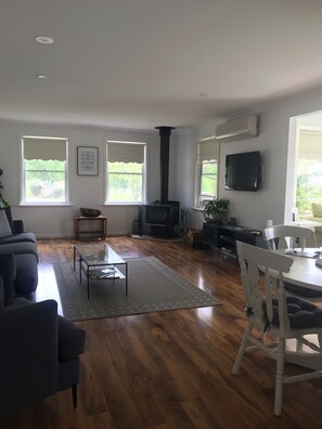 Relax in this spacious living room with a fireplace, flat-screen TV, and dining area.