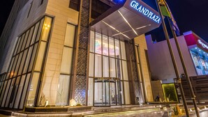 A high-rise hotel with illuminated windows and a prominent 'Grand Plaza' sign.