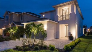 A modern two-story house with a balcony, a driveway, and well-maintained landscaping. - Ultimate 5 Star Villa with Private Pool on Encore Resort at Reunion, Orlando Villa 4363 (Orlando)
