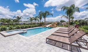 A swimming pool with a slide, lounge chairs, and a stone waterfall feature. - Ultimate 5 Star Villa with Private Pool on Encore Resort at Reunion, Orlando Villa 4365 (Orlando)