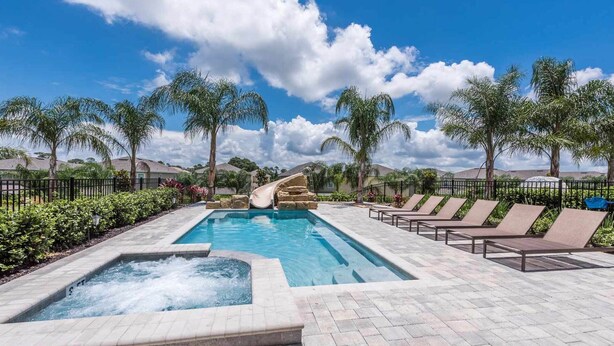 A pool area with a hot tub, lounge chairs, and a slide. - Ultimate 5 Star Villa with Private Pool on Encore Resort at Reunion, Orlando Villa 4365 (Orlando)