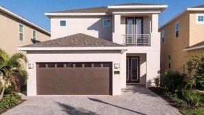 A modern two-story house with a garage, a balcony, and a well-maintained garden. - Ultimate 5 Star Villa with Private Pool on Encore Resort at Reunion, Orlando Villa 4365 (Orlando)