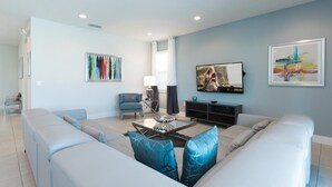 A modern living room with a sectional sofa, a coffee table, and artwork on the walls. - Ultimate 5 Star Villa with Private Pool on Encore Resort at Reunion, Orlando Villa 4365 (Orlando)