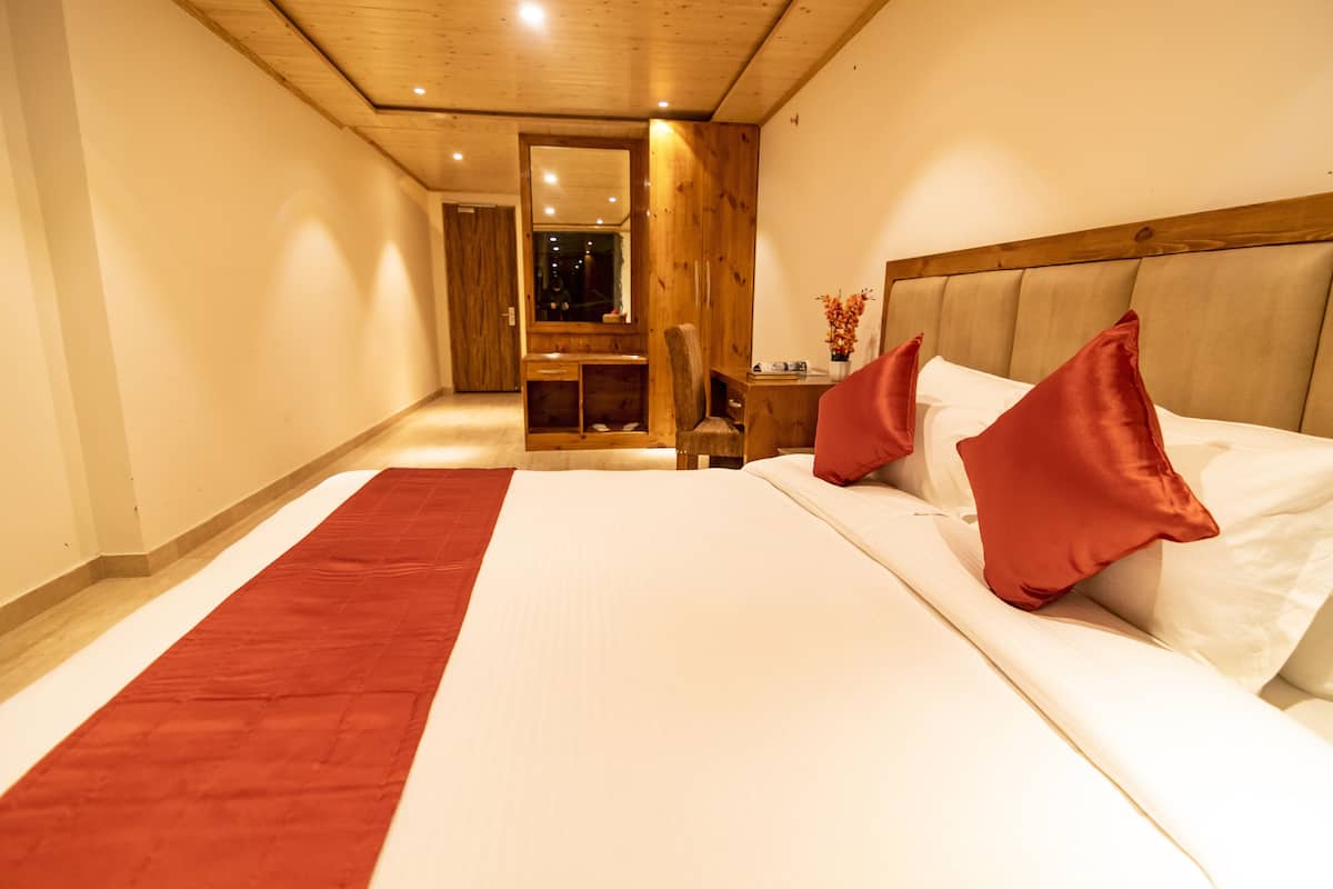 A bedroom with a large bed, a wooden headboard, and a red runner.