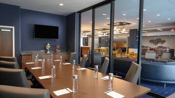 A conference room with a long table, chairs, and water bottles.