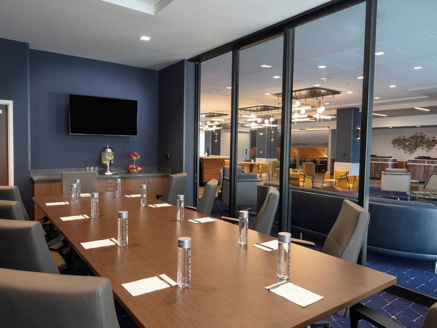 A conference room with a long table, chairs, and water bottles.