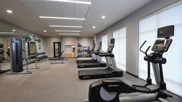 A gym with treadmills, weight machines, and exercise balls.