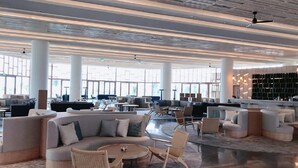 A spacious lobby with modern furniture, large windows, and a high ceiling. - This is an apartment of 5* Alma resort at Bai Dai beach in Khanh Hoa (Nha Trang) (Cam Lam)