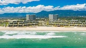 A coastal hotel with multiple buildings, a beach, and mountains in the background. - This is an apartment of 5* Alma resort at Bai Dai beach in Khanh Hoa (Nha Trang) (Cam Lam)