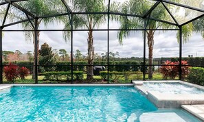 A swimming pool with a glass enclosure, surrounded by palm trees and a landscaped garden. - Exclusive Villa with Large Private Pool on Encore Resort at Reunion, Orlando Villa 4383 (Kissimmee)