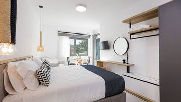 Una camera d'albergo moderna con un letto grande, una scrivania, una sedia, una televisione e una finestra che offre vista sull'esterno.