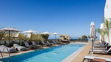 Una piscina al aire libre de temporada, sombrillas