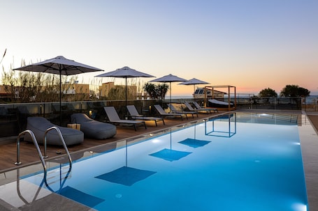 Una piscina al aire libre de temporada, sombrillas