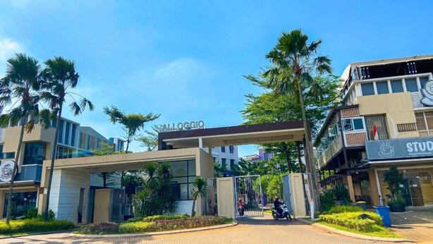 A modern building with a sign reading "ALLOGGIO" and another sign for "STUDIOS" indicating a food and beverage area. - Aloha Guest House 2 (Gading Serpong)