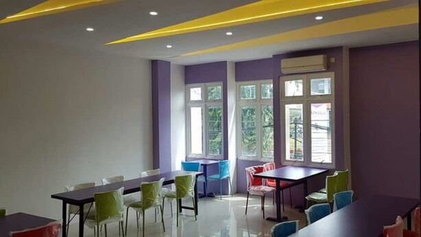 A conference room with a long table and chairs, large windows, and an air conditioning unit on the wall.