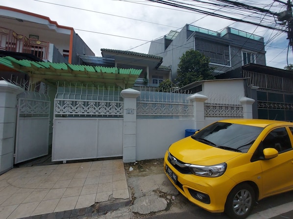 A gated residential area with a yellow car parked in front.