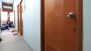Ein Flur mit Holztüren, einer Decken-Klimaanlage und einem sichtbaren Wasserspender.