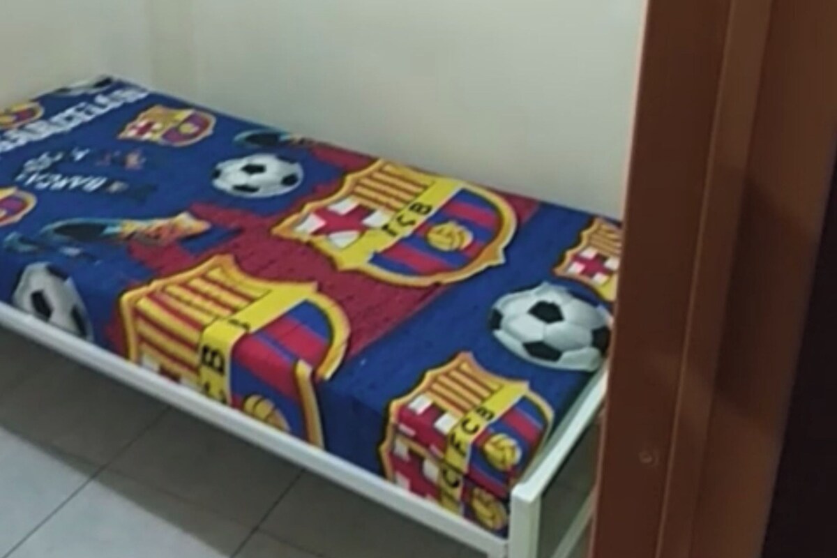 Un letto singolo con materasso blu e copriletto a tema con il Barcellona.