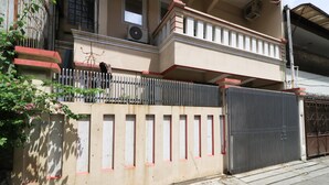 Een gebouw met een balkon, een hekpoort en een raam met airconditioning.