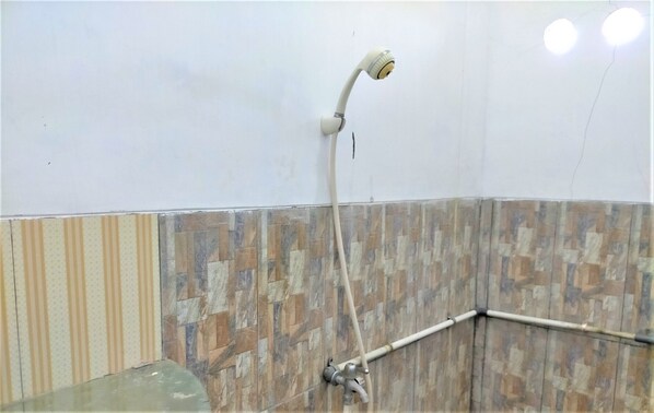A shower with a handheld showerhead and a wall-mounted faucet. - Kendang Kempul Hostel (Banyuwangi)