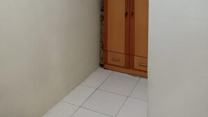 Ein schlichter, kleiner Raum mit schlichten Wänden und einem Holzschrank.