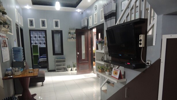 A reception area with a flat-screen TV, a reception desk, and a water dispenser.