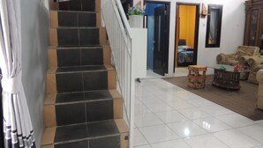 A staircase leading to a bedroom with a bed, a small table, and a chair.