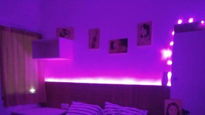 Une chambre à coucher avec un lit, une table de chevet et des œuvres d’art murales.