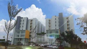 Un immeuble d’appartements moderne, doté de plusieurs étages, de grandes fenêtres et d’un espace de stationnement à l’avant.