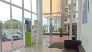Un espace d’accueil doté d’une porte en verre, d’un banc noir et d’une affiche annonçant une réduction de 500.