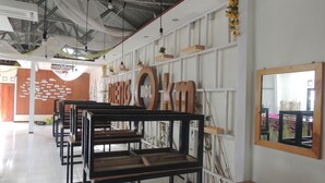 Un interior moderno con filas de sillas de metal negro, paredes blancas y un techo con vigas a la vista.