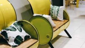 A modern interior with a yellow and green seating area, a staircase, and a white wall with a door. - I Cloud Residence (Surabaya)