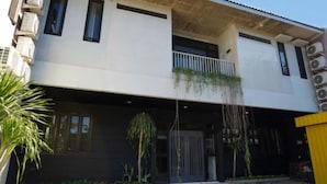 A two-story building with a flat roof, large windows, and a covered entrance area. - I Cloud Residence (Surabaya)