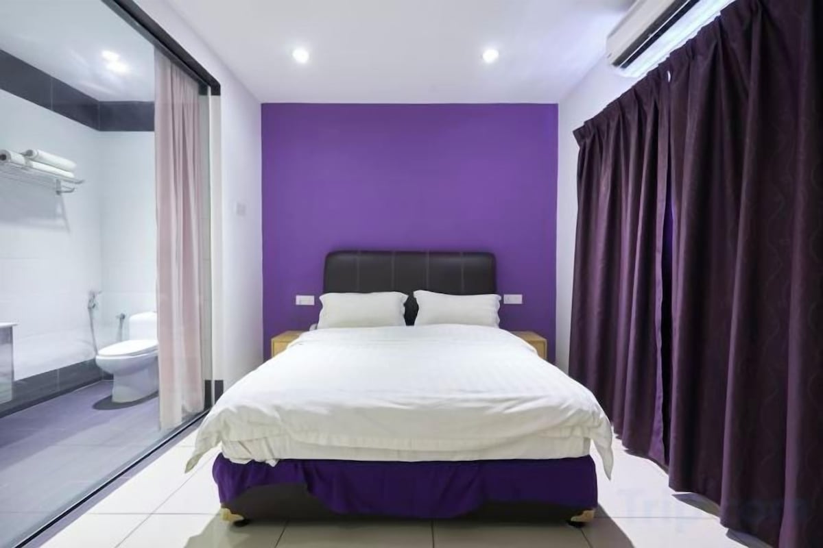 A room with a bed, a window, and a bathroom.