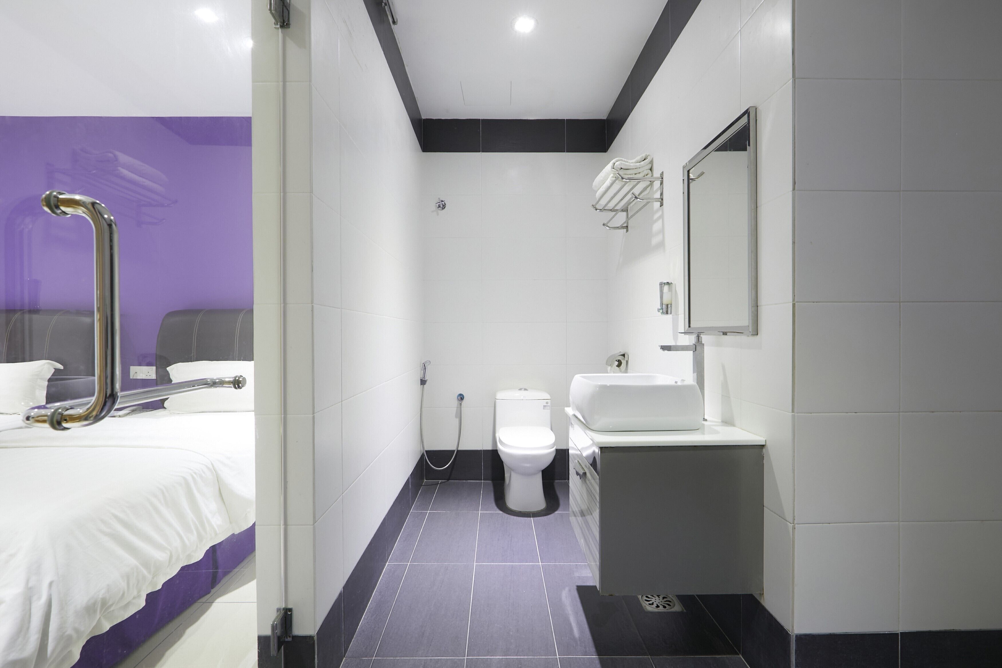 A modern bathroom with a shower, toilet, and sink.