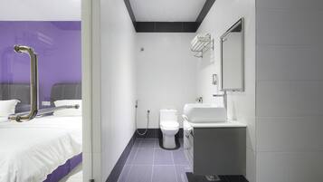 A modern bathroom with a shower, toilet, and sink.