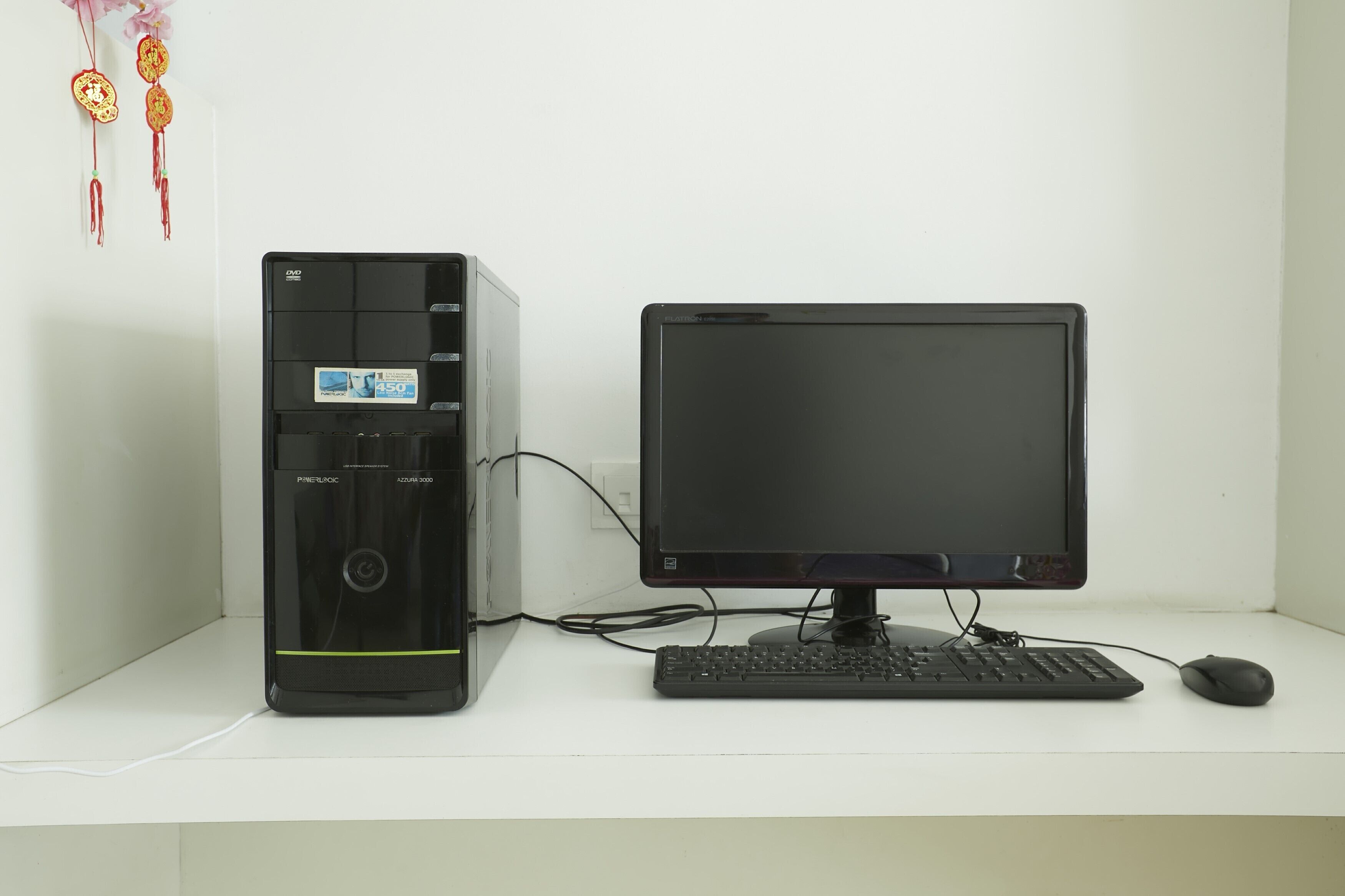 Una computadora de escritorio con monitor, teclado y ratón sobre un escritorio blanco.