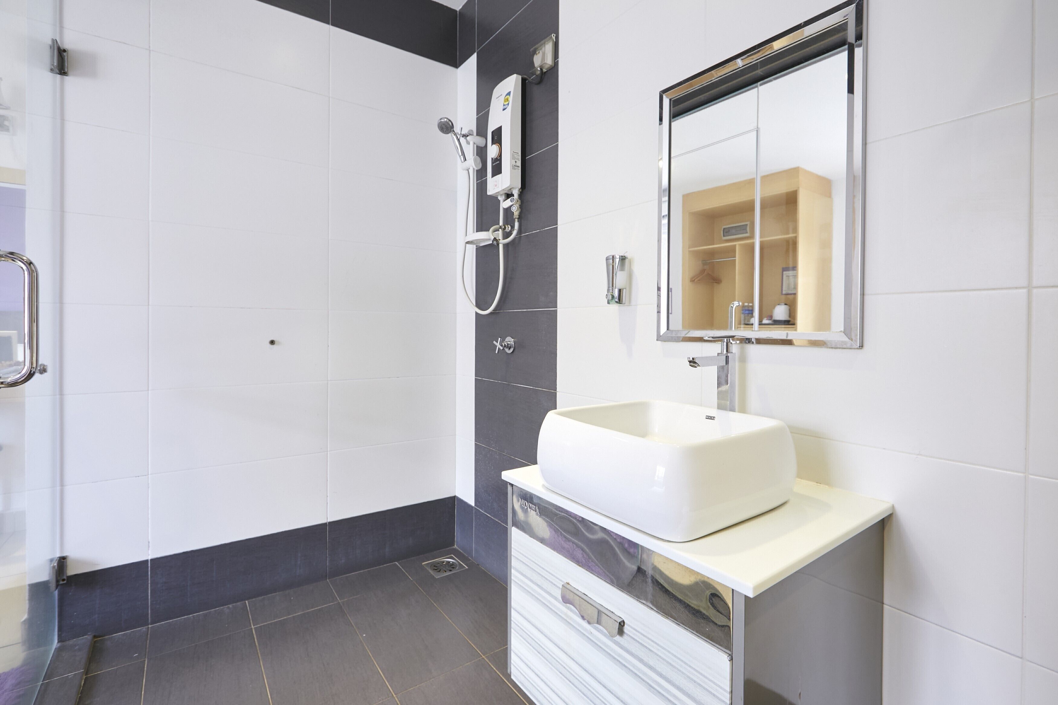 Ein modernes Badezimmer mit einem weißen Waschbecken, einem Spiegel und einer Duschkabine.
