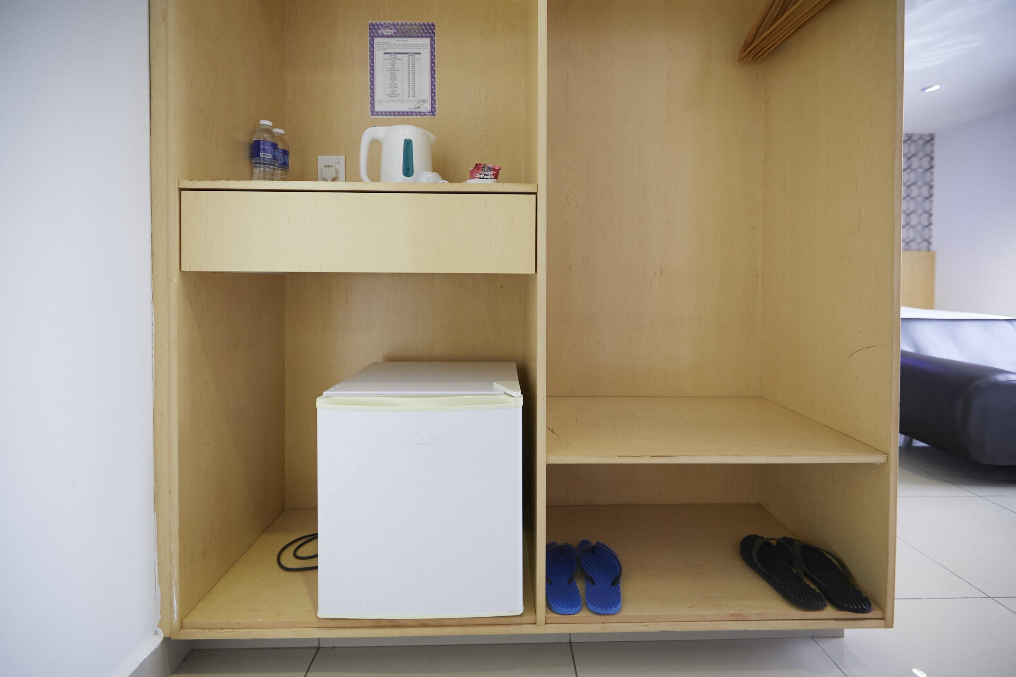 A wooden wardrobe with a top shelf, a middle shelf, and a bottom shelf.