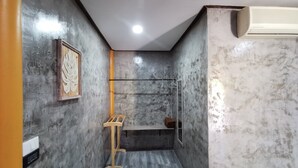 A small, narrow bathroom with a wooden stool, a towel rack, and a mirror. - Viman Resort (Si Racha)