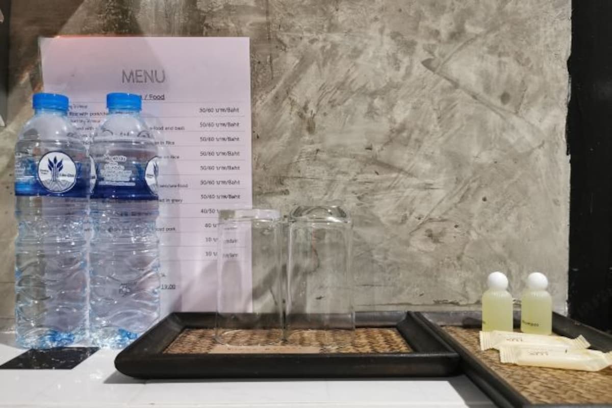 A menu board, water bottles, and a tray with food items.