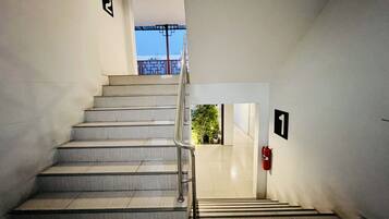 Una escalera con barandilla metálica que lleva a una puerta con el número 1.