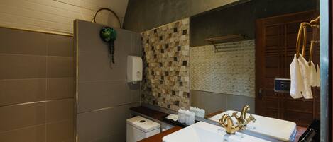 A modern bathroom with a large mirror, a white sink, and a shower area.