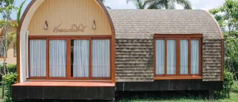 A small, two-room structure with a curved roof and wooden exterior.