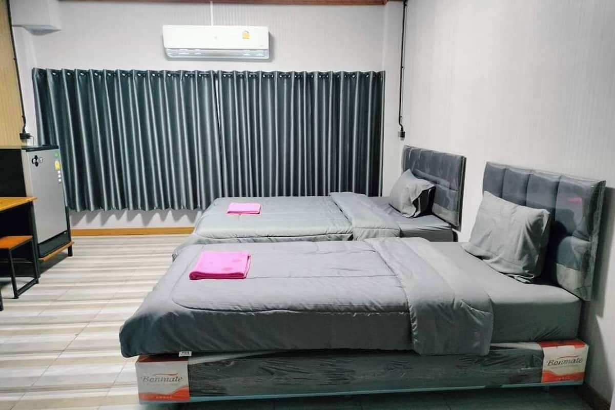 A hotel room with two beds, a desk, and a chair.