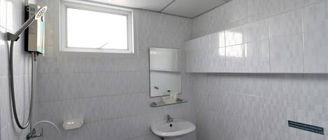 Un baño con ducha, lavabo e inodoro.