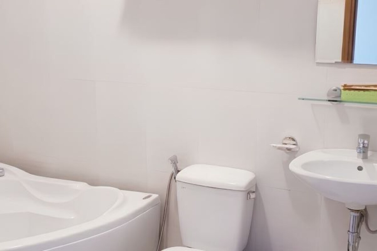 A bathroom with a bathtub, toilet, and sink.