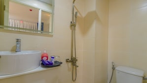 Ein Badezimmer mit Waschbecken, Spiegel, Dusche und Toilette.