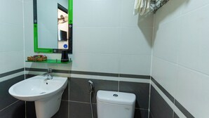 A bathroom with a white sink, a toilet, and a mirror with a green frame. - Prince Hotel (Ho Chi Minh City)