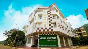 A multi-story building with a green signboard reading "ĐƠNG PHƯƠNG" and a checkered pattern on the facade. - Dong Phuong Hotel (Quy Nhon Nam)